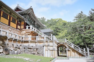 a stone building with a gate and steps leading to it