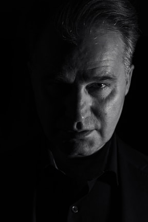 Close-up portrait of Juan Baraza in deep shadow, capturing intense emotion.