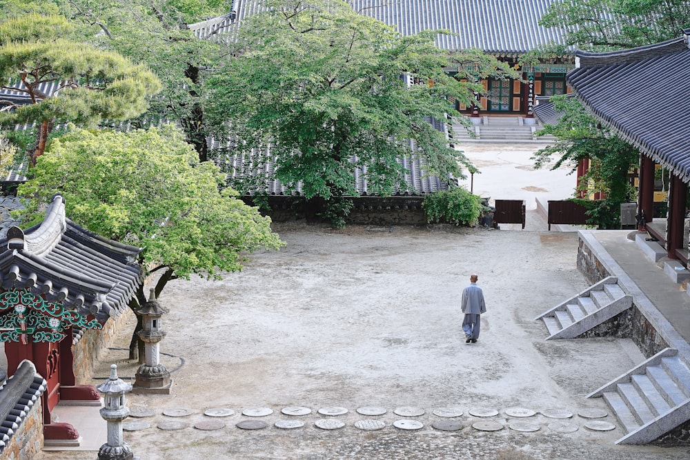 a man standing in a courtyard surrounded by trees