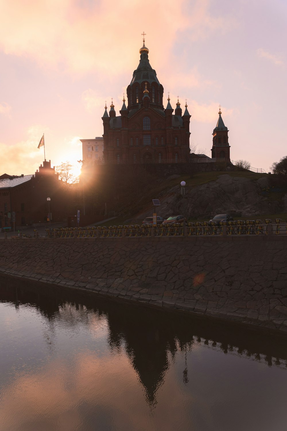 the sun is setting behind a large building