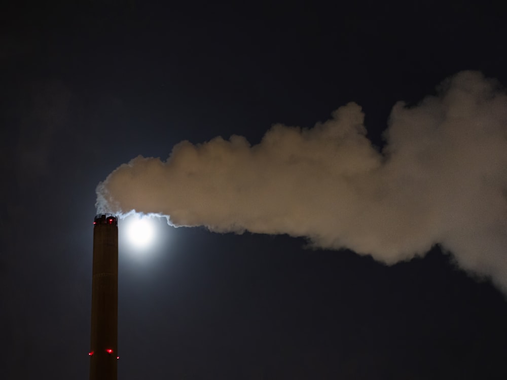 a smokestack emits from a chimney at night