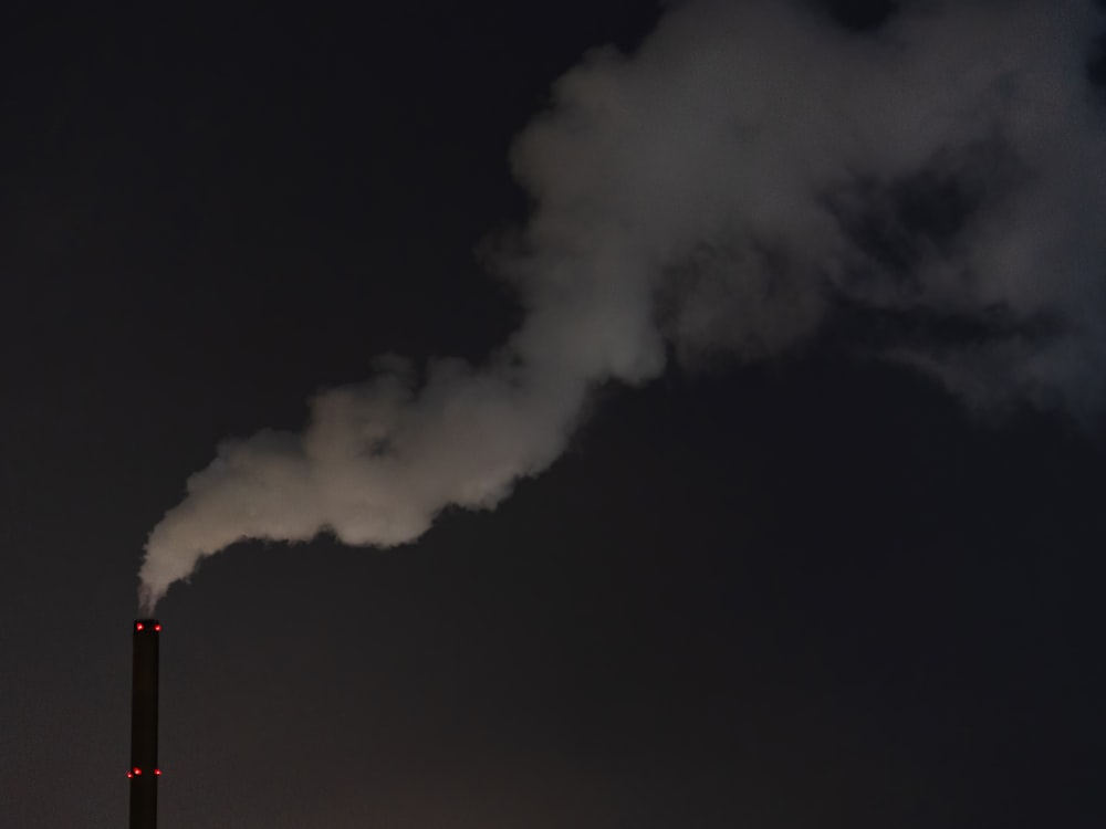 a smokestack emits from a building at night