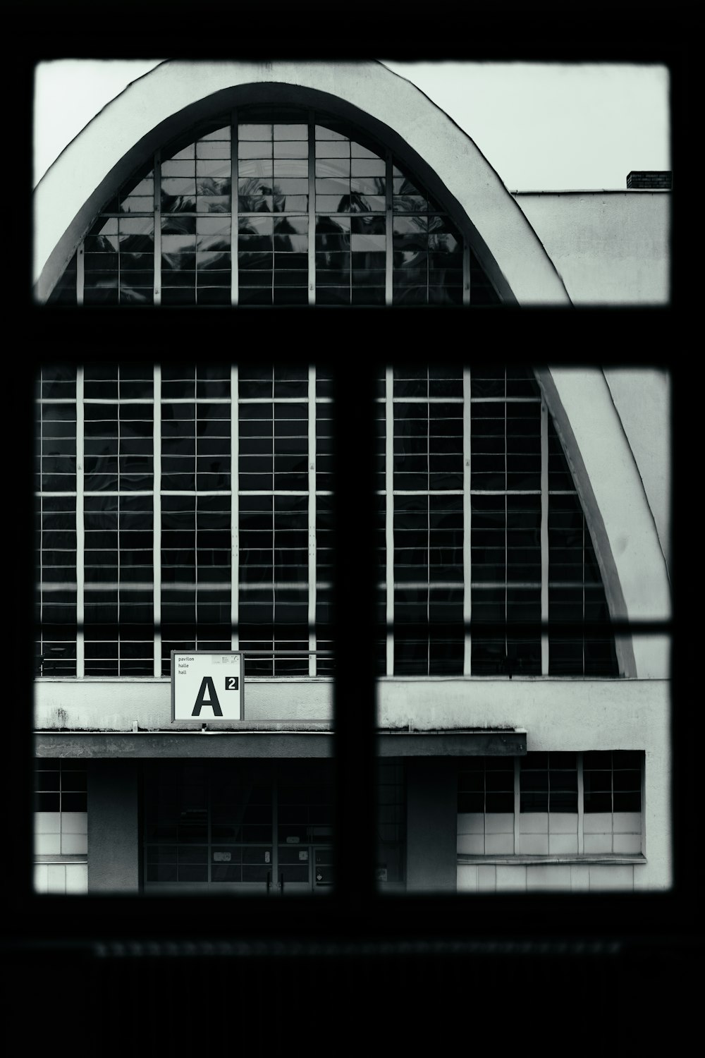 a black and white photo of a building through a window