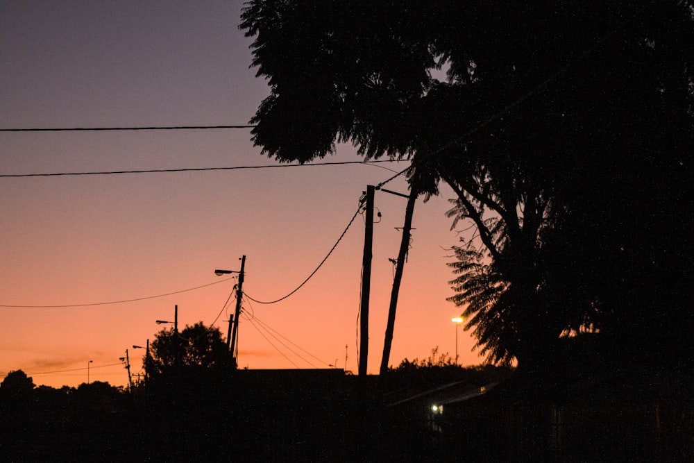 the sun is setting in the distance behind power lines