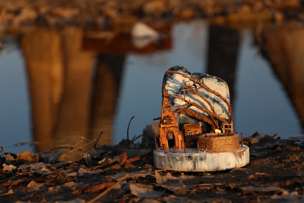 an old chair sitting on the ground next to a body of water