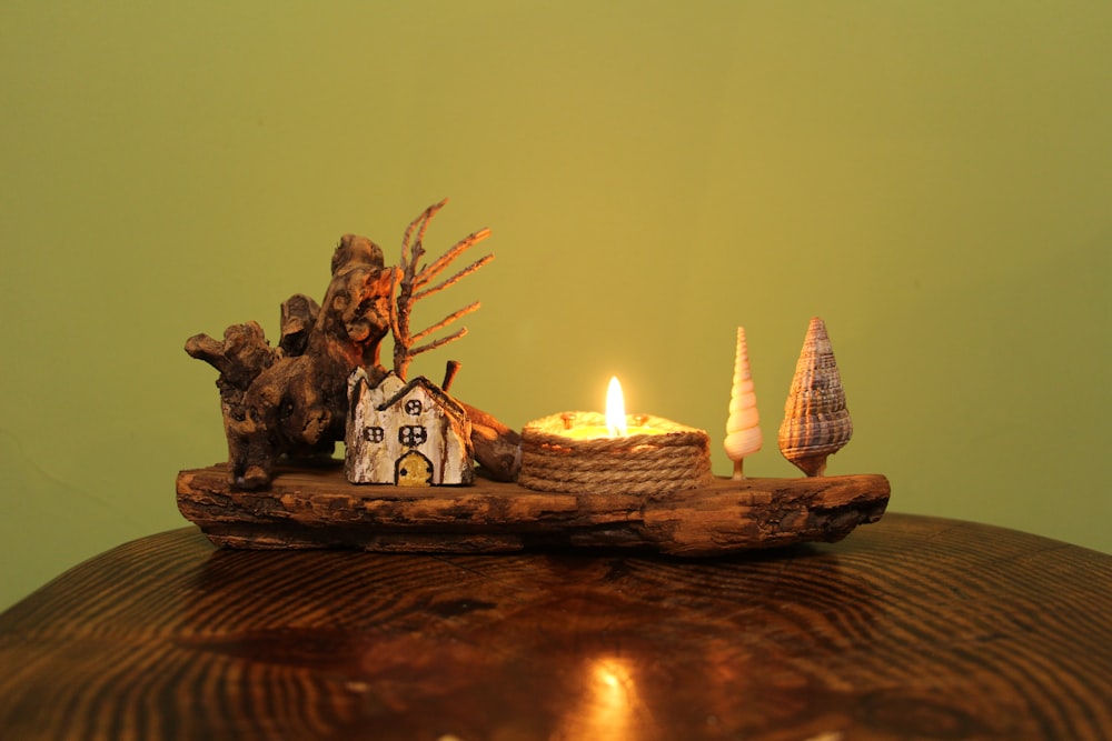 a wooden table topped with a lit candle