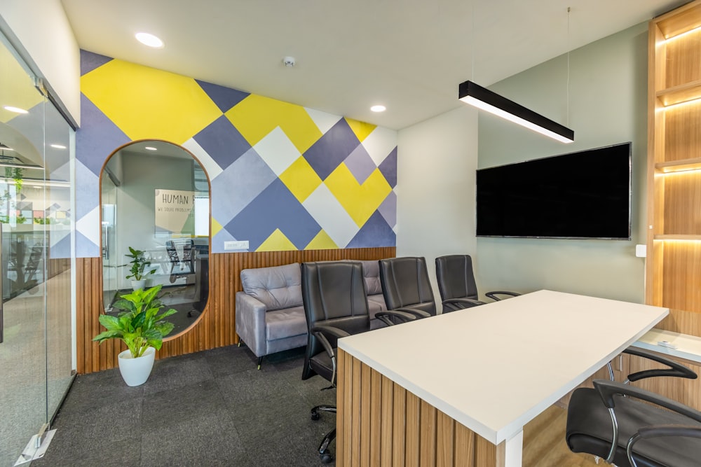 an office with a desk, chairs and a large mirror