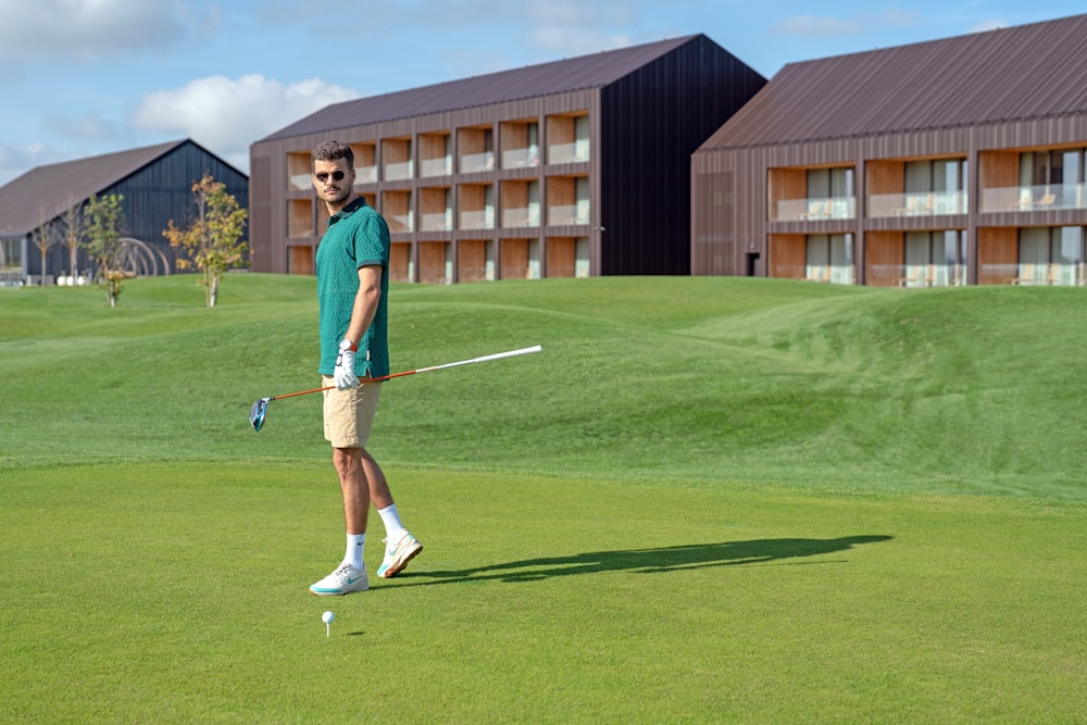 a man walking across a lush green golf course