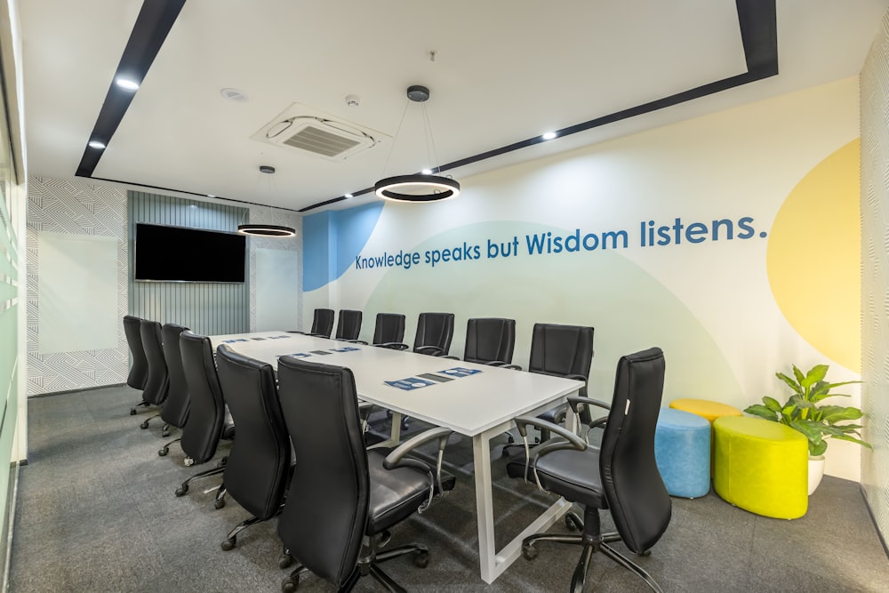 a conference room with a white table and black chairs