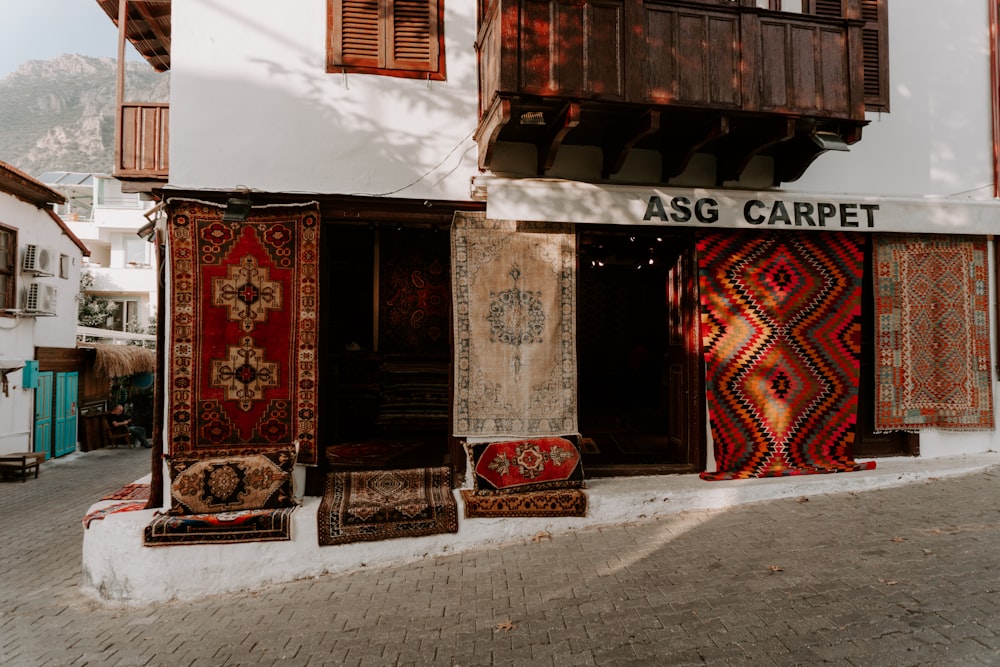 a group of rugs sitting outside of a building