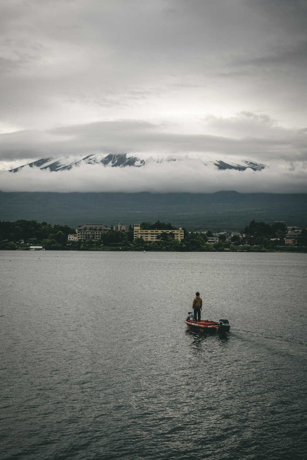 um homem em pé em um barco no meio de um lago