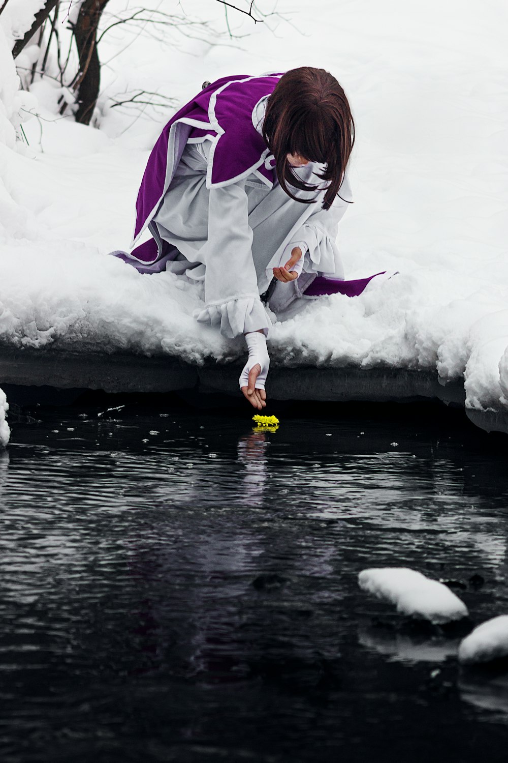 a woman in a purple and white dress is playing with a yellow frisbee