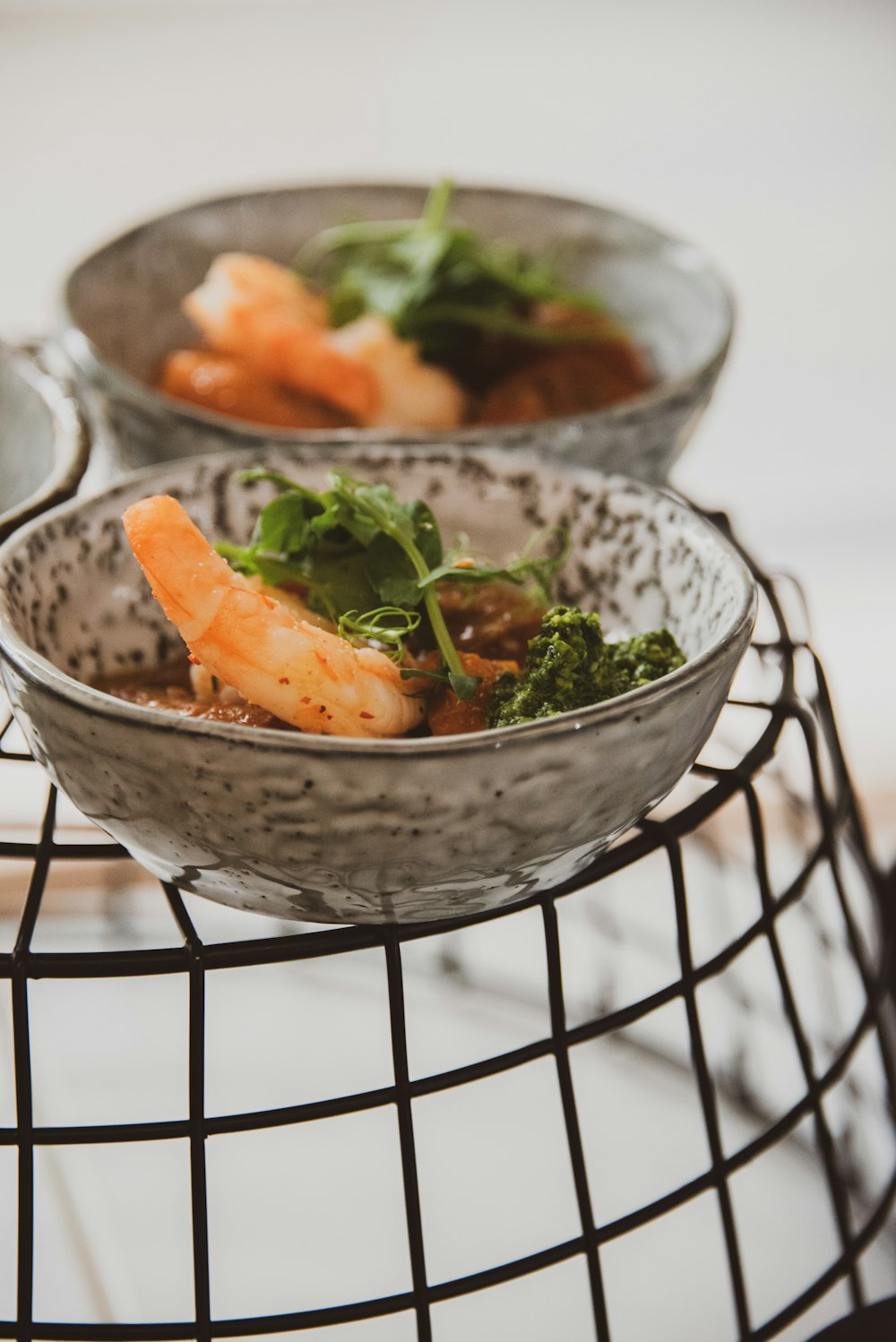 two bowls of food are sitting on a wire rack