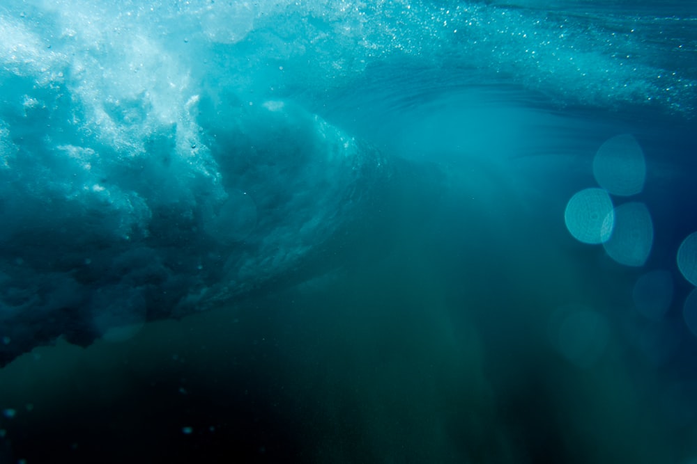 a large wave in the ocean with bubbles