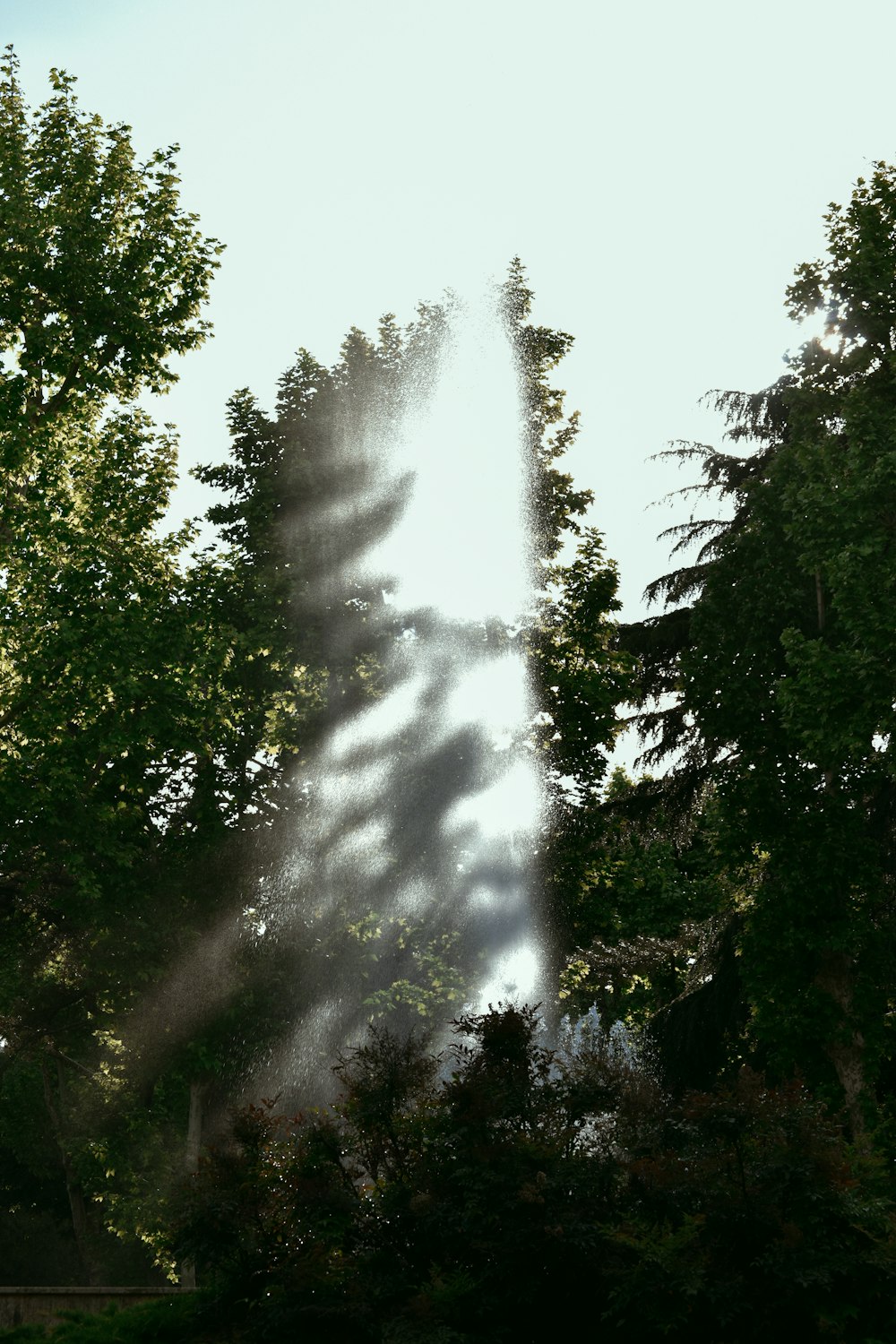 a sprinkle of water is coming out of the top of a tall tower