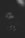 A dimly lit image with soft focus, featuring a subtle close-up of a small flower or bud against a dark background. The photo has a moody and mysterious feel.