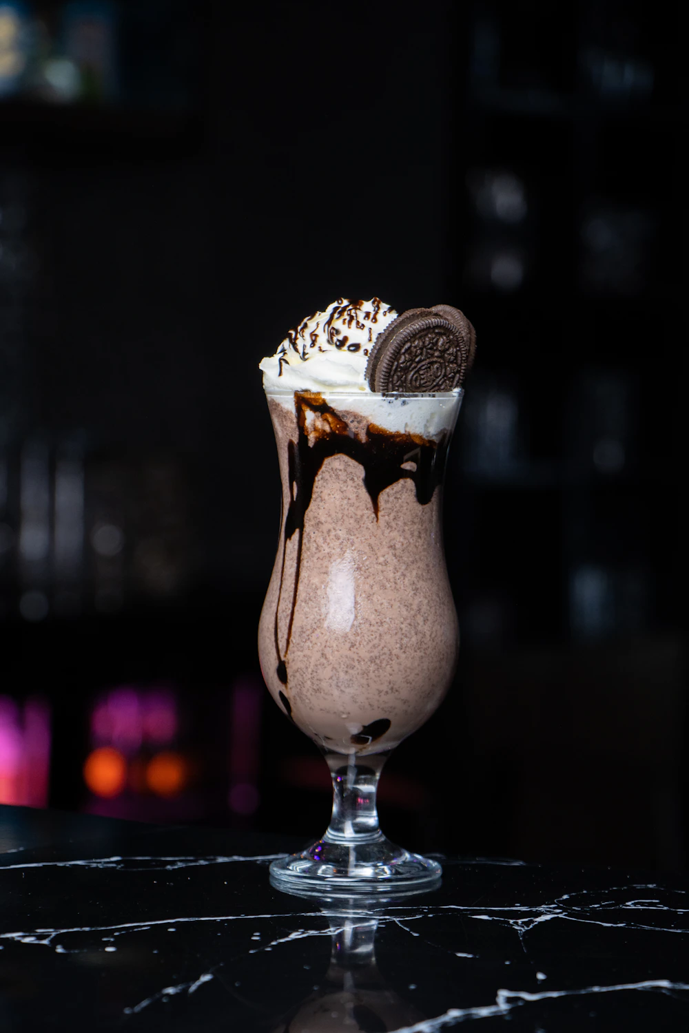 Chocolate milkshake topped with whipped cream and a cookie garnish.