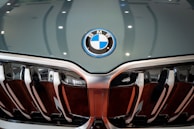 Close-up of a BMW's golden emblem shining against a black grille.