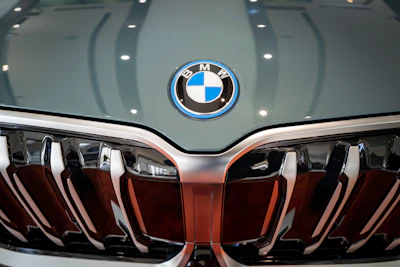 A close-up of a polished BMW grille reflecting soft cerulean lighting.