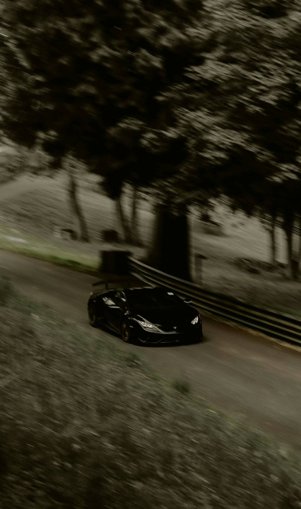 a black sports car driving down a road