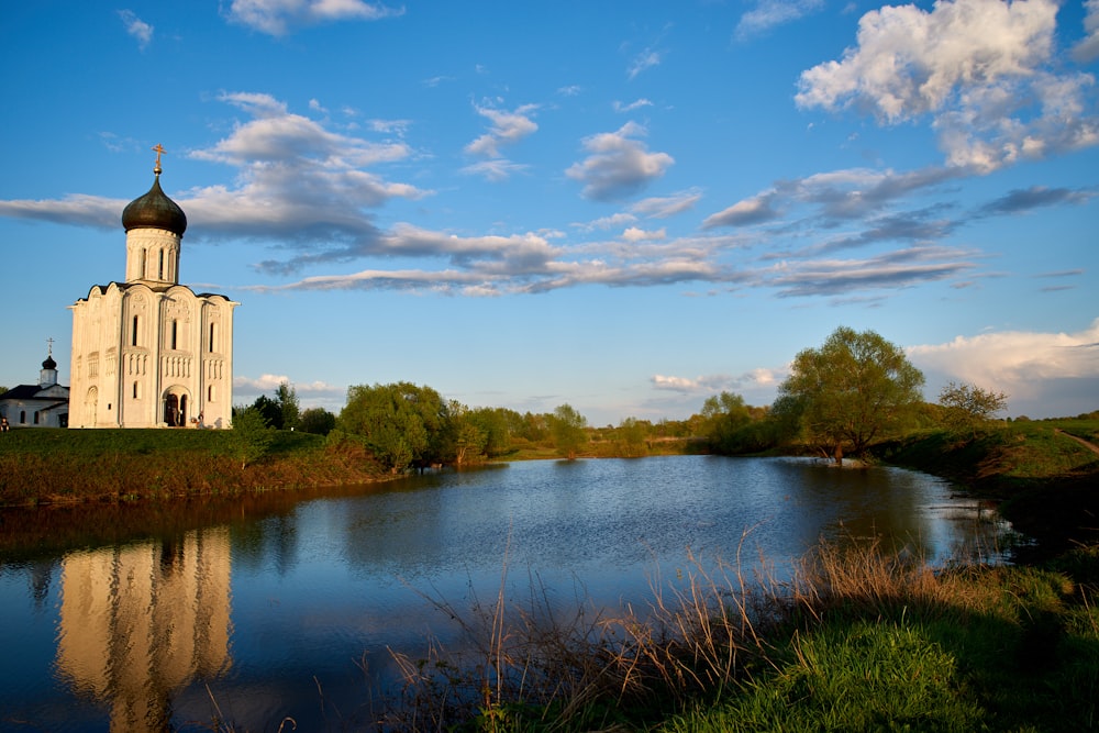 a large white church sitting on top of a lush green field