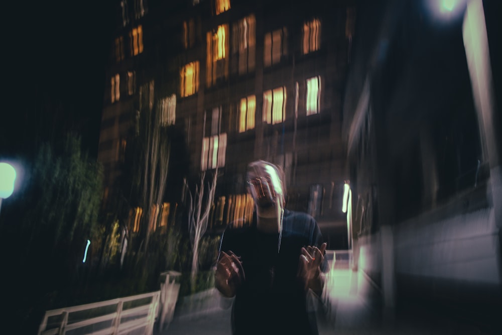 a blurry photo of a woman walking down a street at night