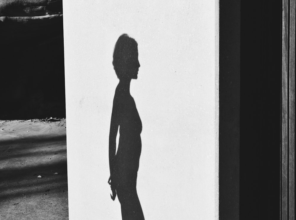 a black and white photo of a woman's shadow