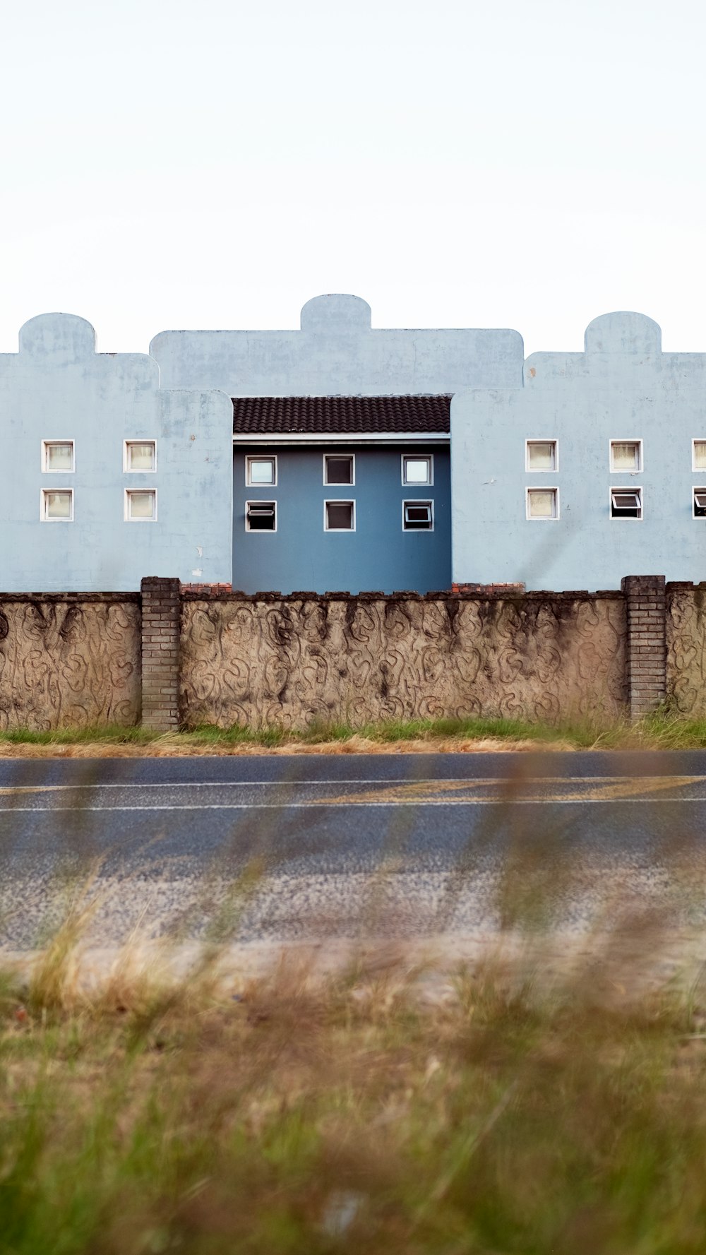 a blue building sitting on the side of a road