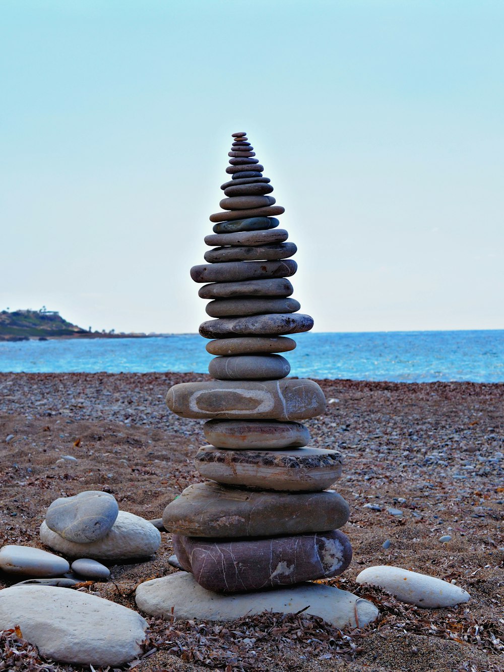 a stack of rocks sitting on top of a sandy beach