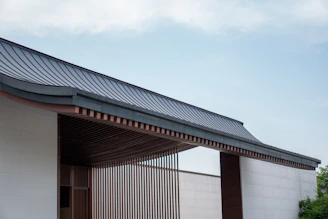 a building with a metal roof and a white wall