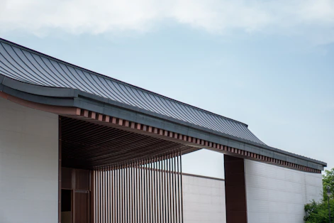a building with a metal roof and a white wall