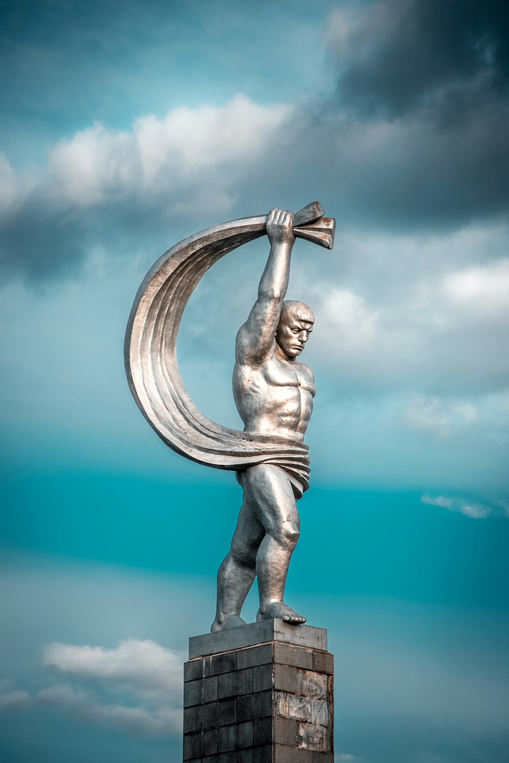 a statue of a man holding a large metal object
