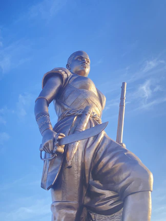 Portrait of a Mesopotamian warrior clad in ancient armor, standing against a backdrop of a golden cliff at sunset.