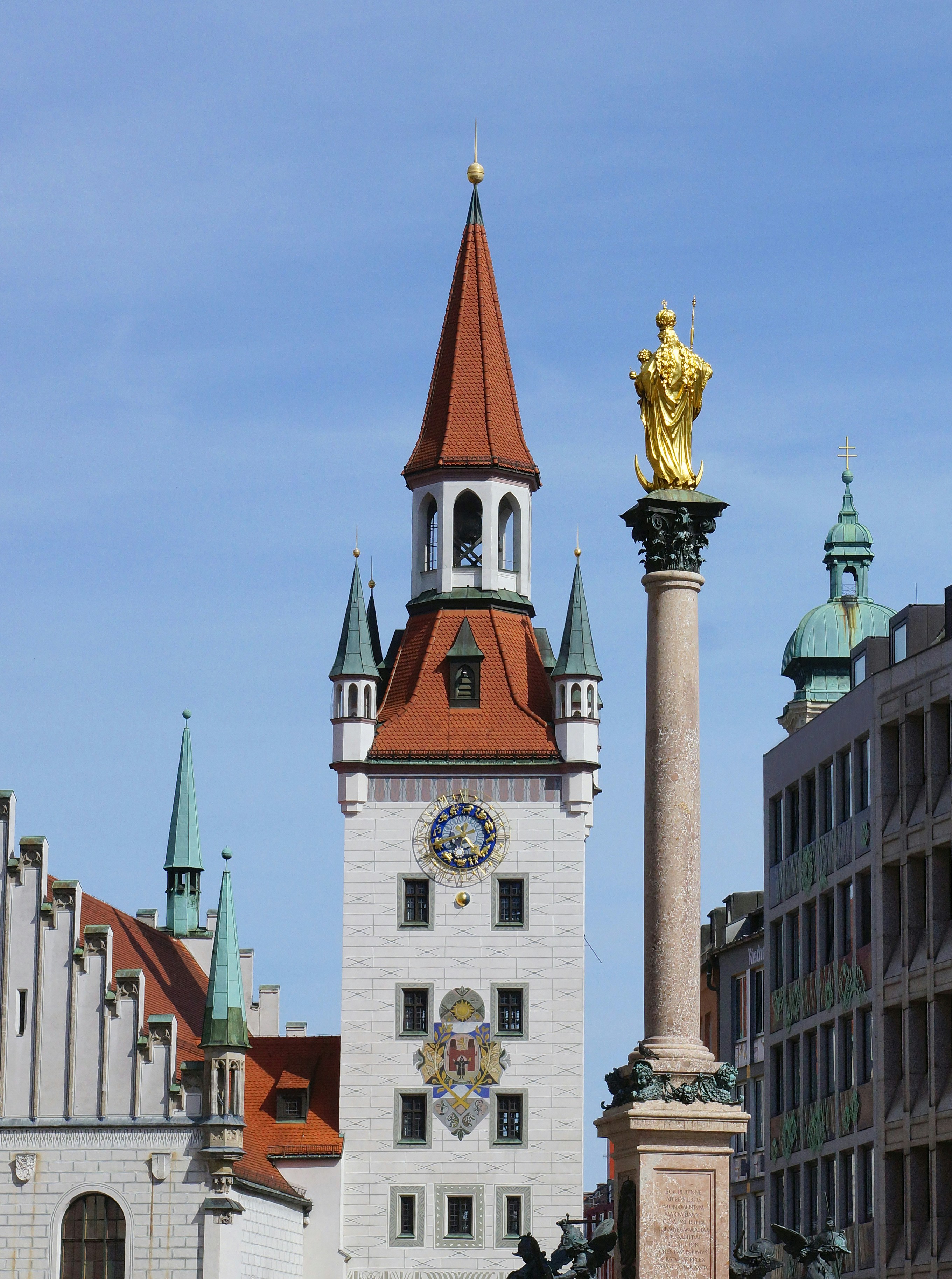 a tall white building with a gold statue on top of it
