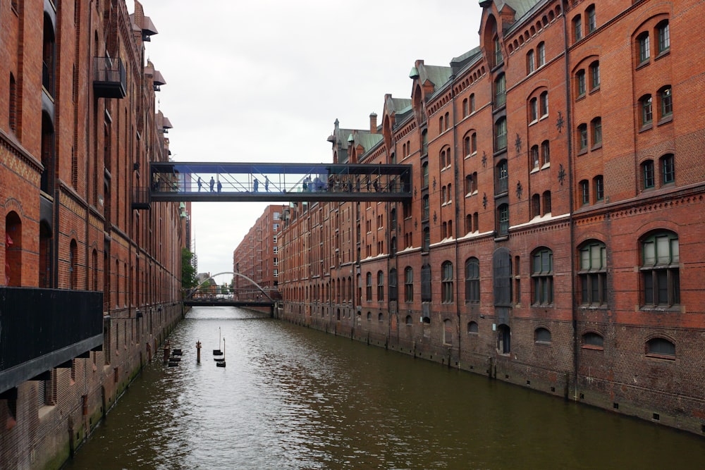 a bridge over a river between two buildings