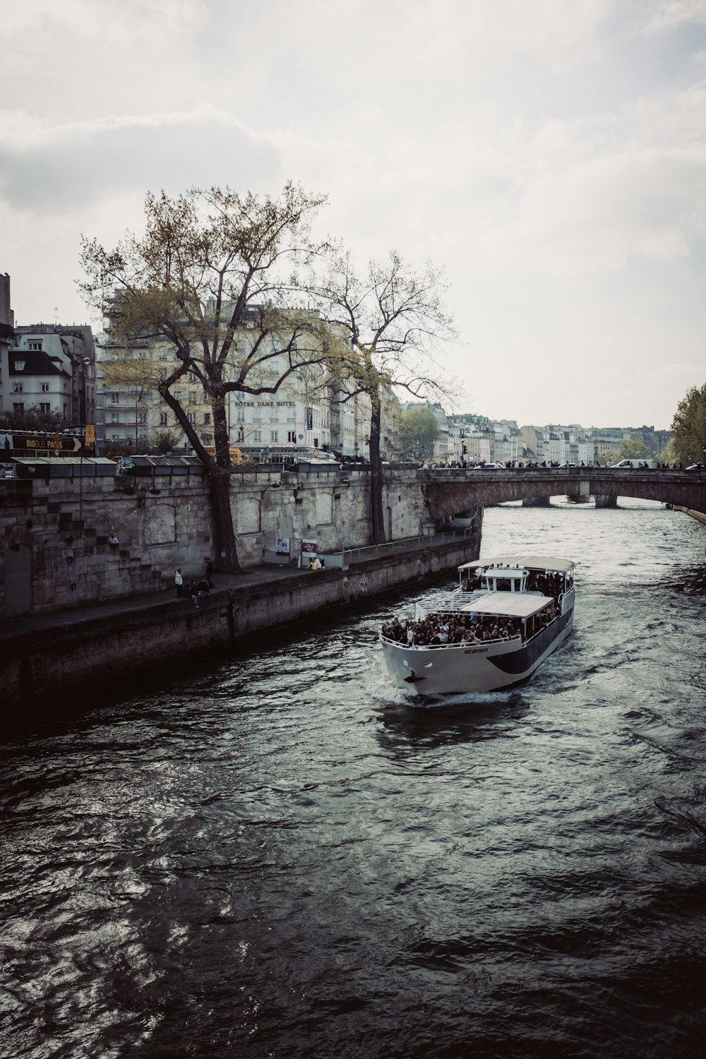 a boat traveling down a river next to a bridge