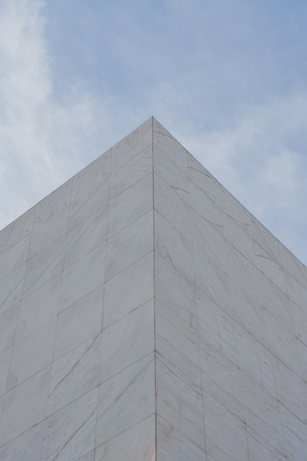 a tall white building with a sky in the background