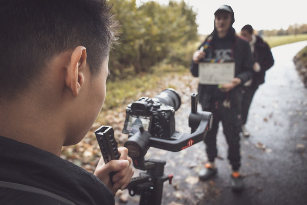 a man holding a camera next to another man