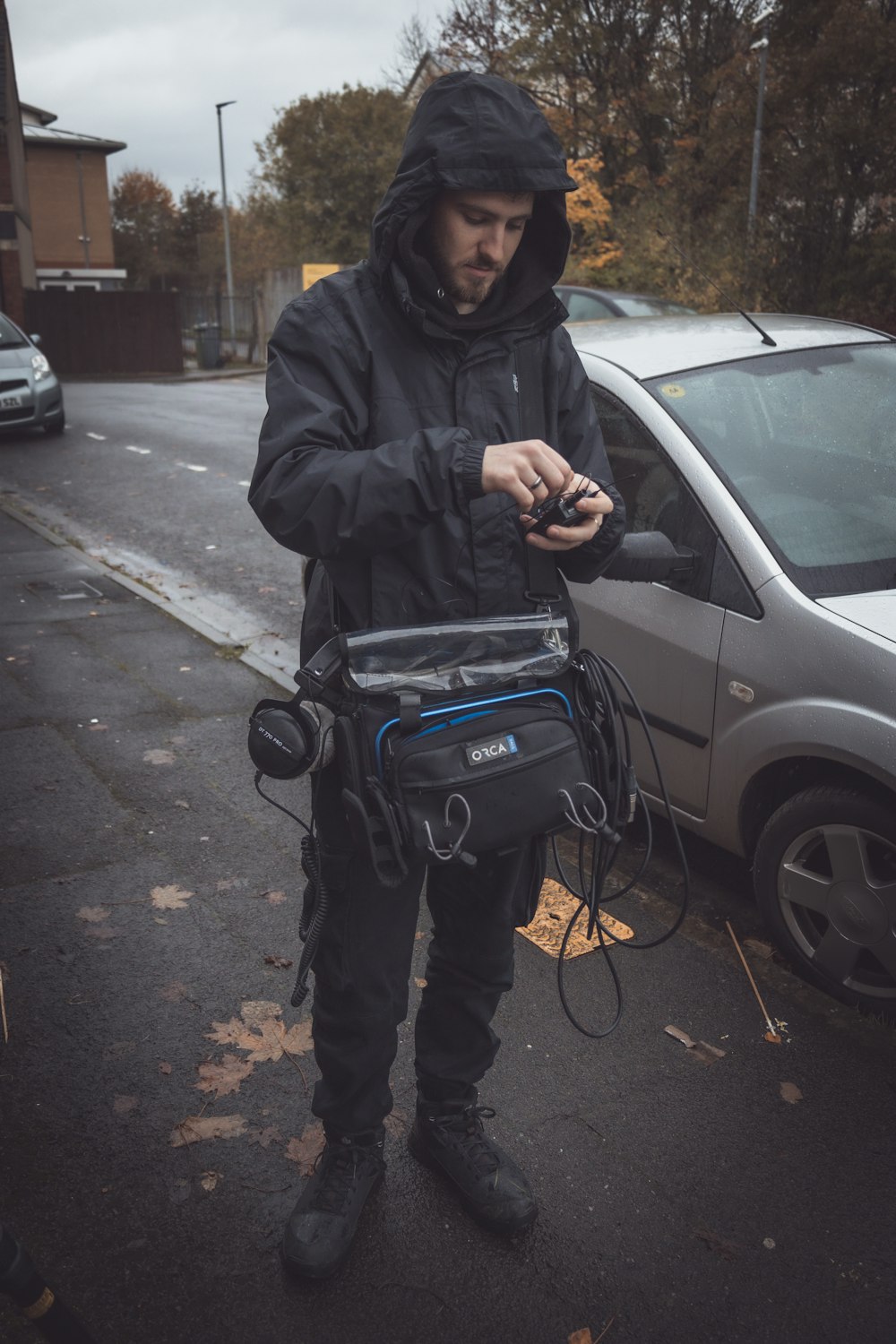 a man in a black jacket is looking at his cell phone