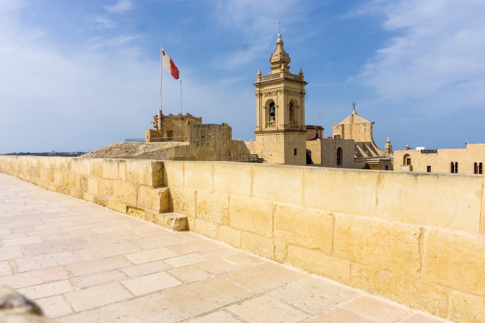 a stone wall with a clock tower in the background