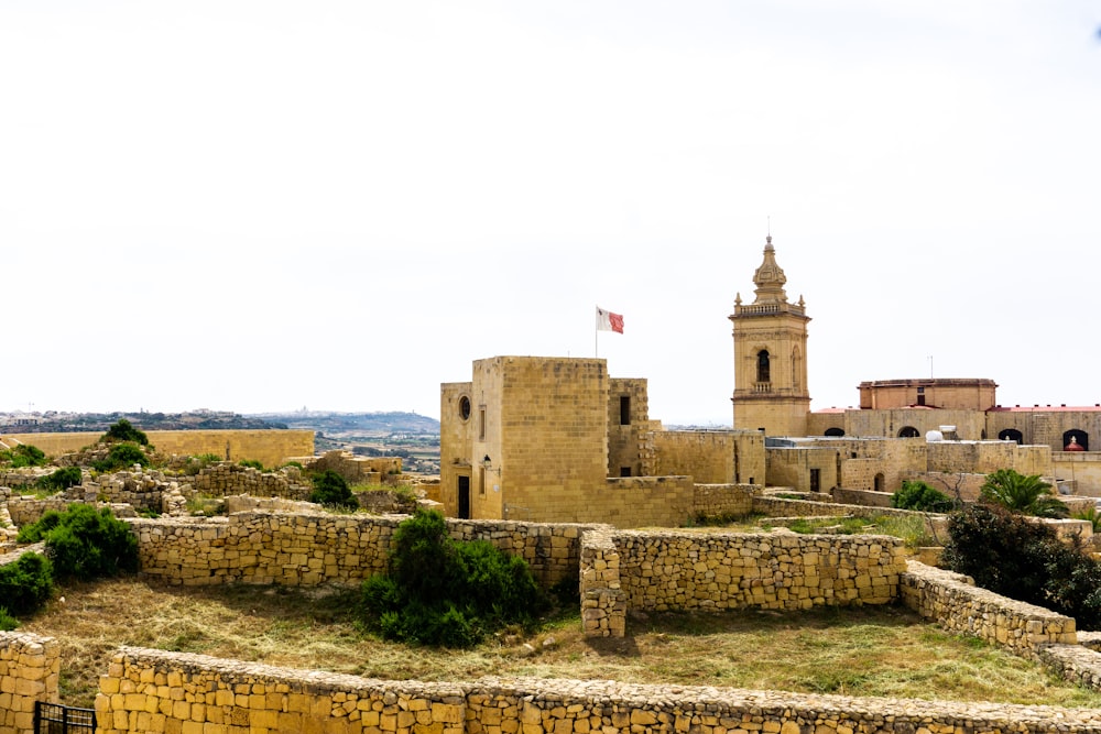 Un castello di pietra con una torre dell'orologio sullo sfondo