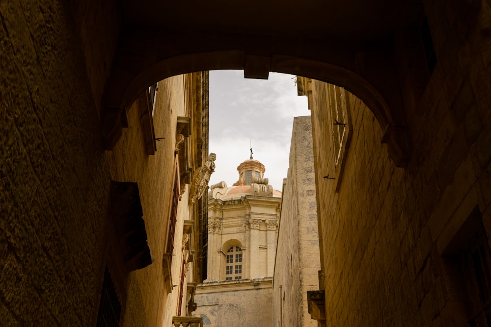 a narrow alley way with a clock tower in the distance