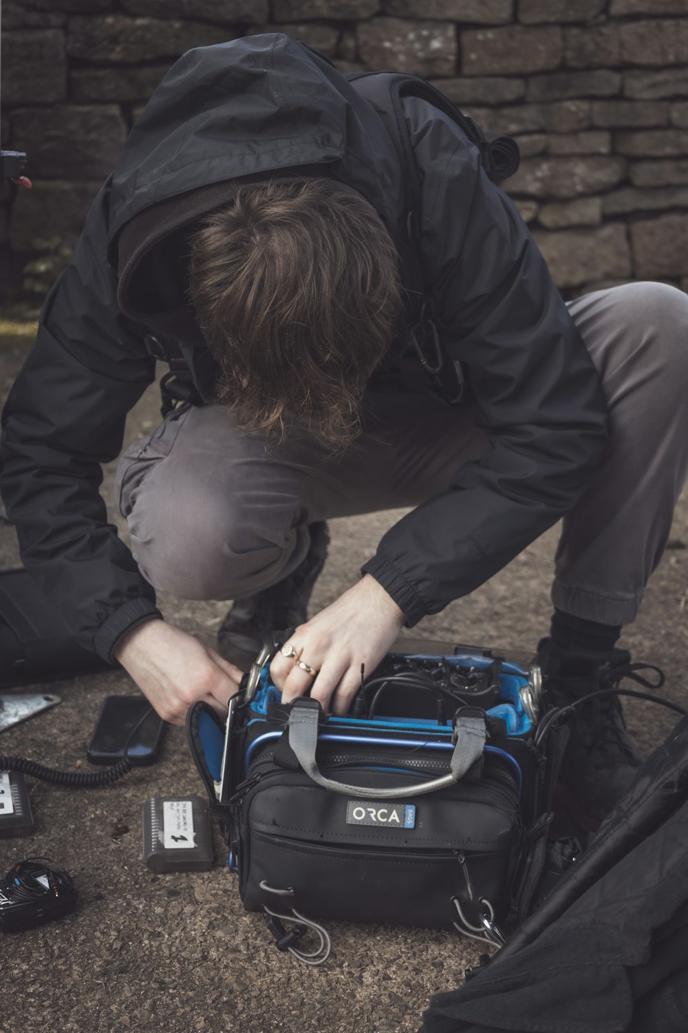 a man kneeling down next to a black and blue bag