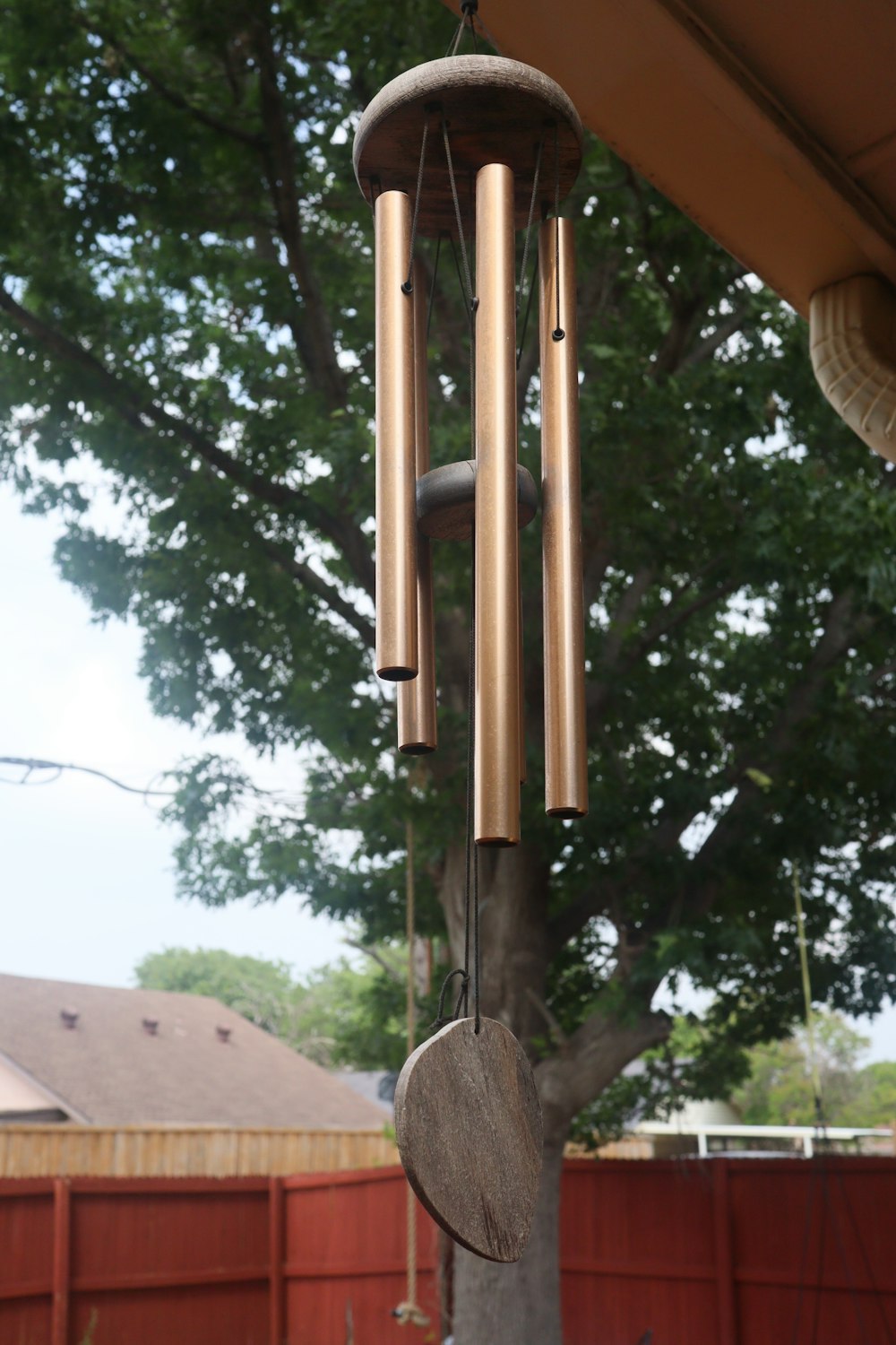 a wind chime hanging from the side of a tree