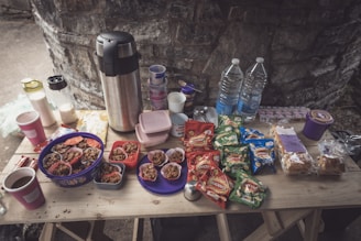 An inviting display of assorted snacks and drinks on a rustic wooden table.