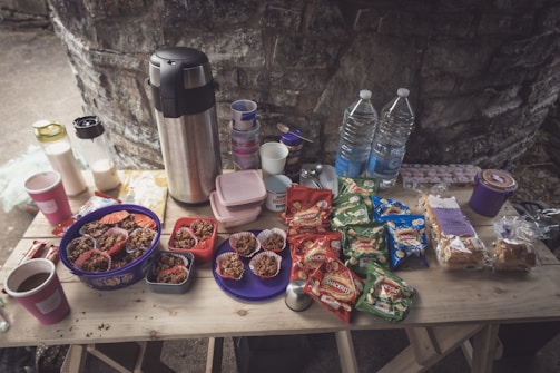 An inviting display of assorted snacks and drinks on a rustic wooden table.