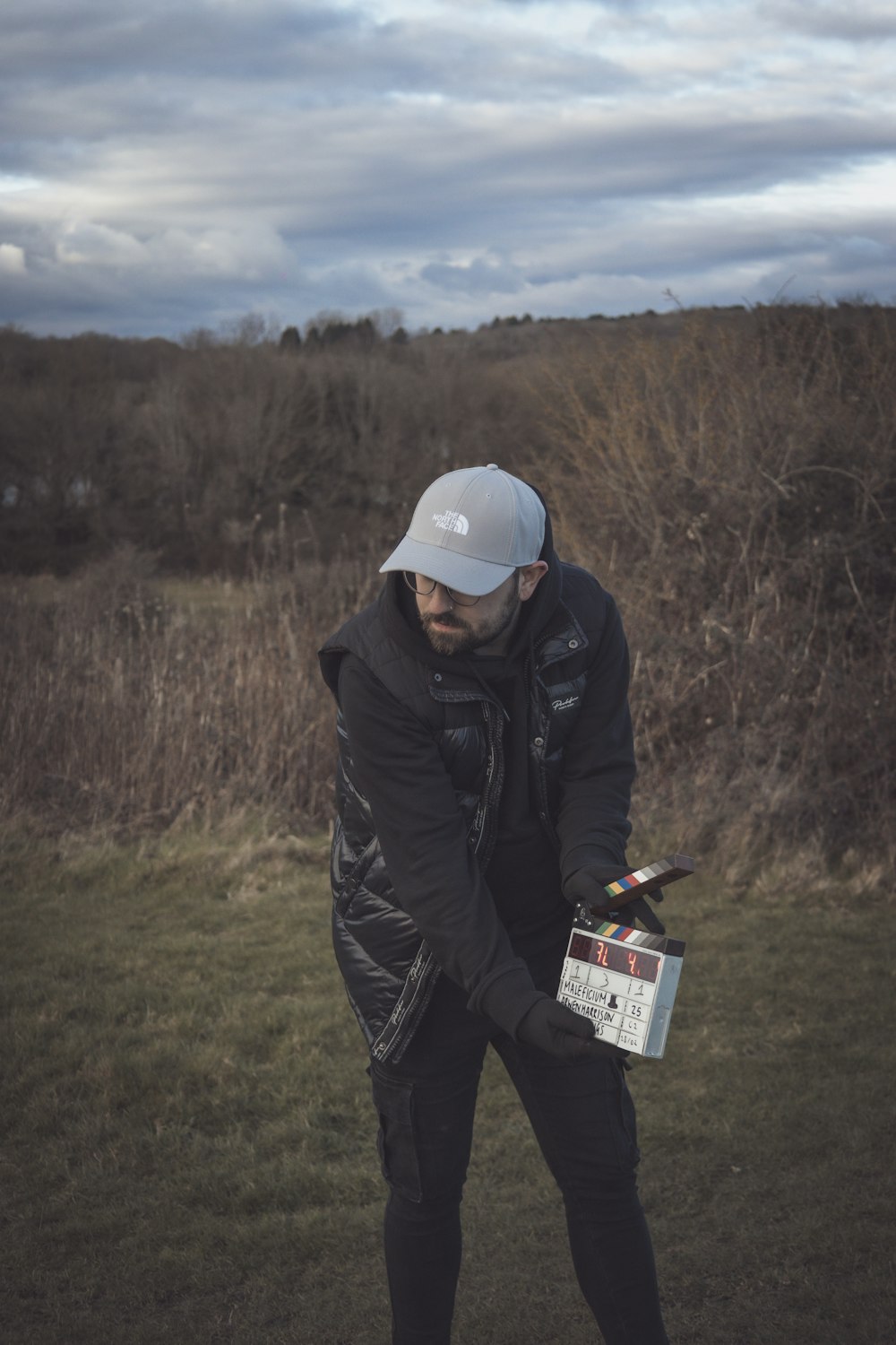 a man holding a camera in a field