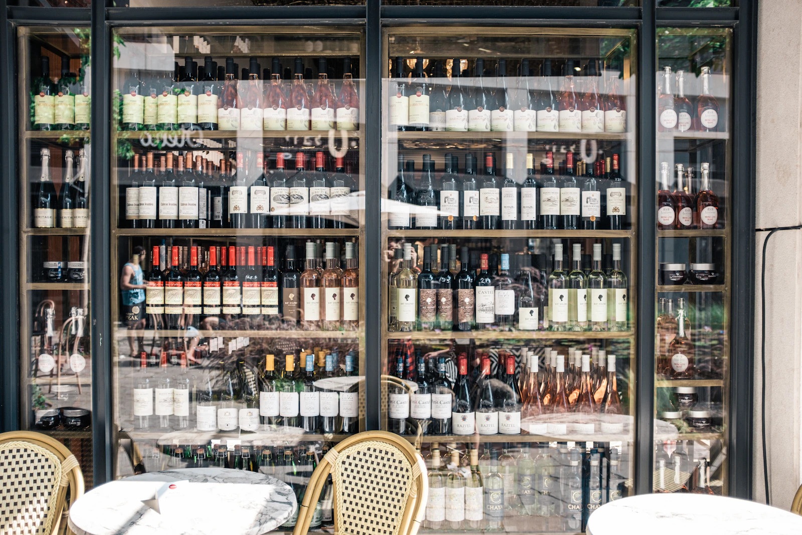 A wine shop with many bottles of wine behind glass