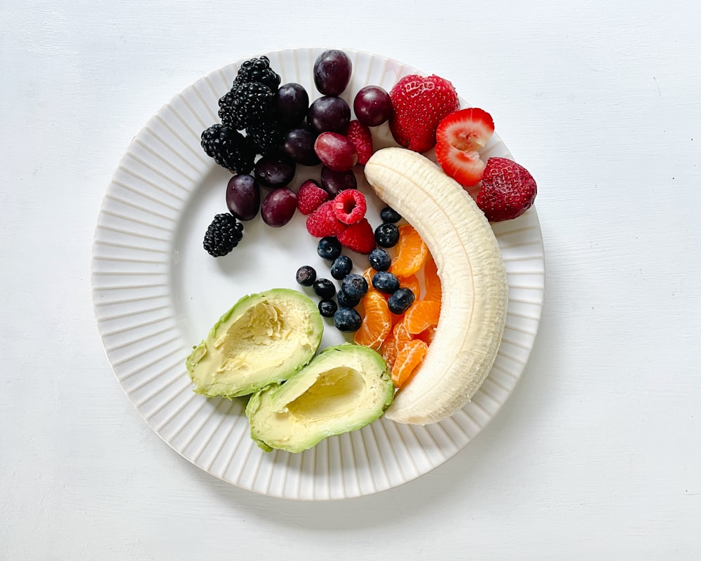 un plato blanco cubierto con frutas y verduras