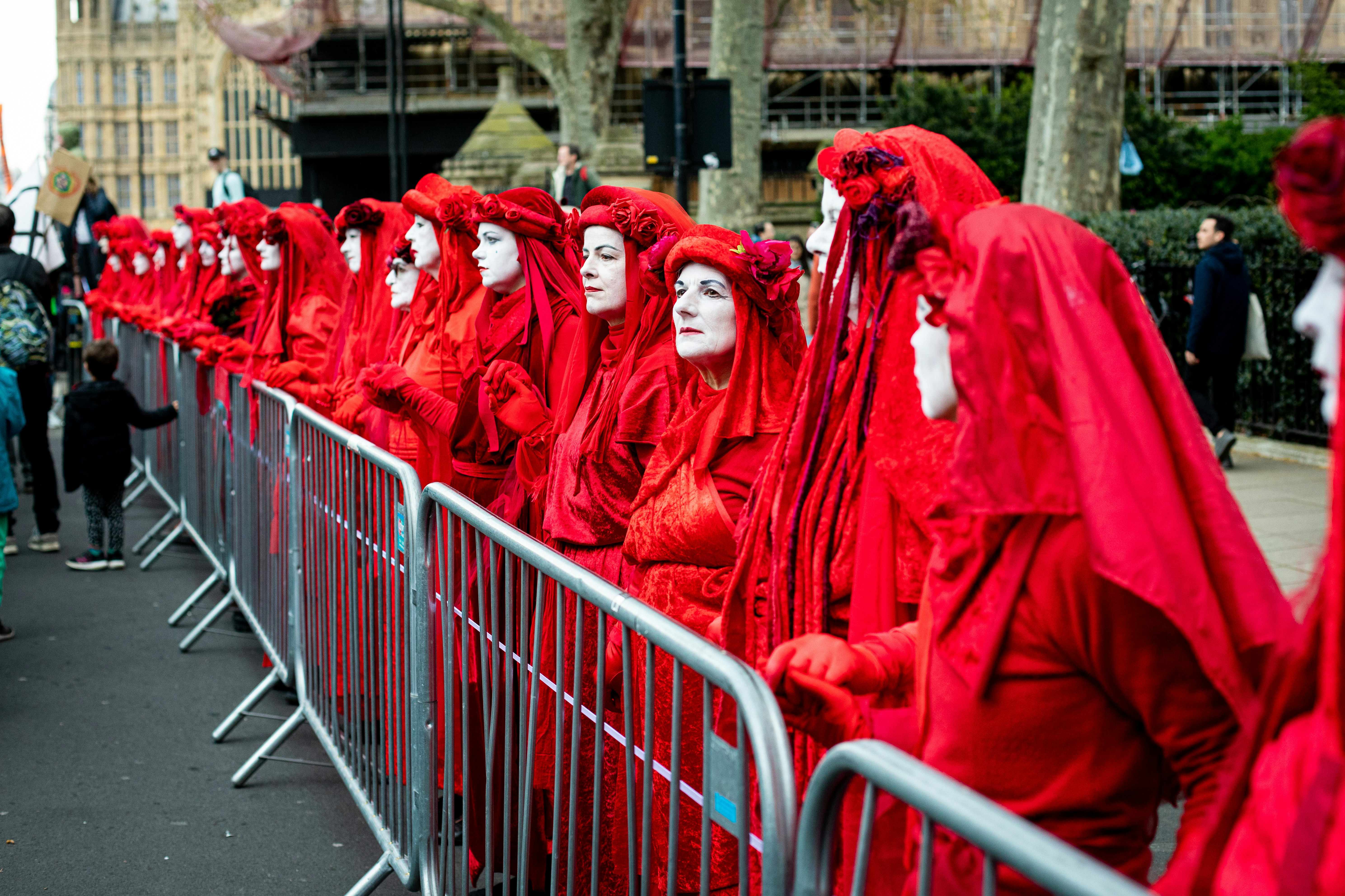Un gruppo di persone in costumi rossi allineati dietro una recinzione